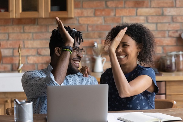 Happy excited Black mixed race couple celebrating an enhanced home buyer experience