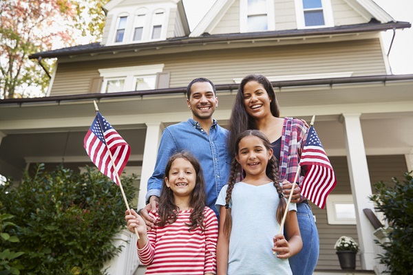 Portrait Of Family Outside House Holding American Flags enjoying summer