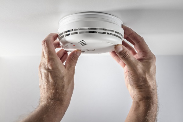 Home smoke detector man installing, maintenance, checking, testing or replacing battery